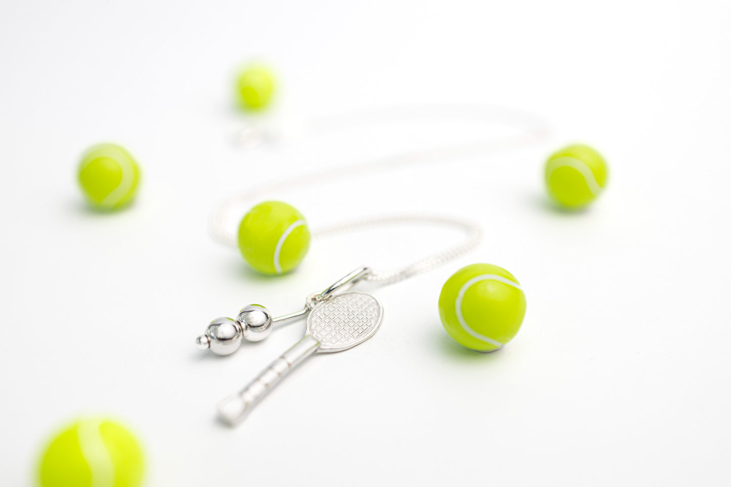 silver tennis racket necklace with yellow tennis balls