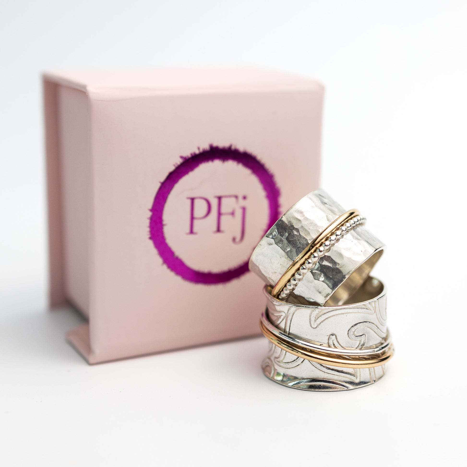 sterling silver spinner ring embedded lotus flower pattern finished beaded outer ring and gold filled outer ring pictured here with the presentation box pink with pfj logo