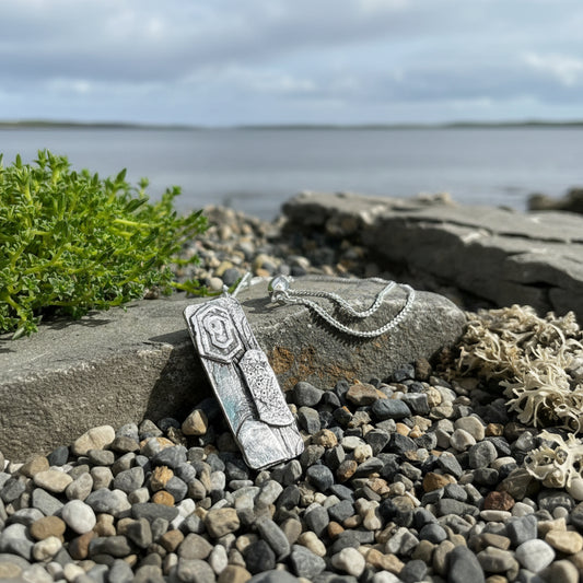 Silver necklace with a pendant on a stone surface