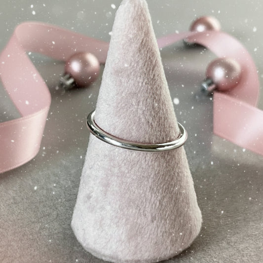 Felted cone-shaped object with a metal ring on a gray surface