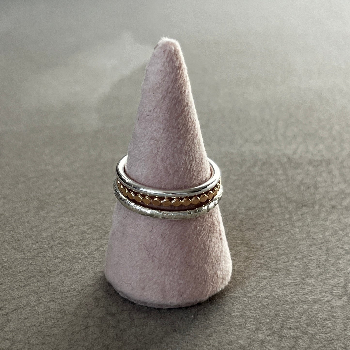 Ring on a cone-shaped gray stand against a gray background
