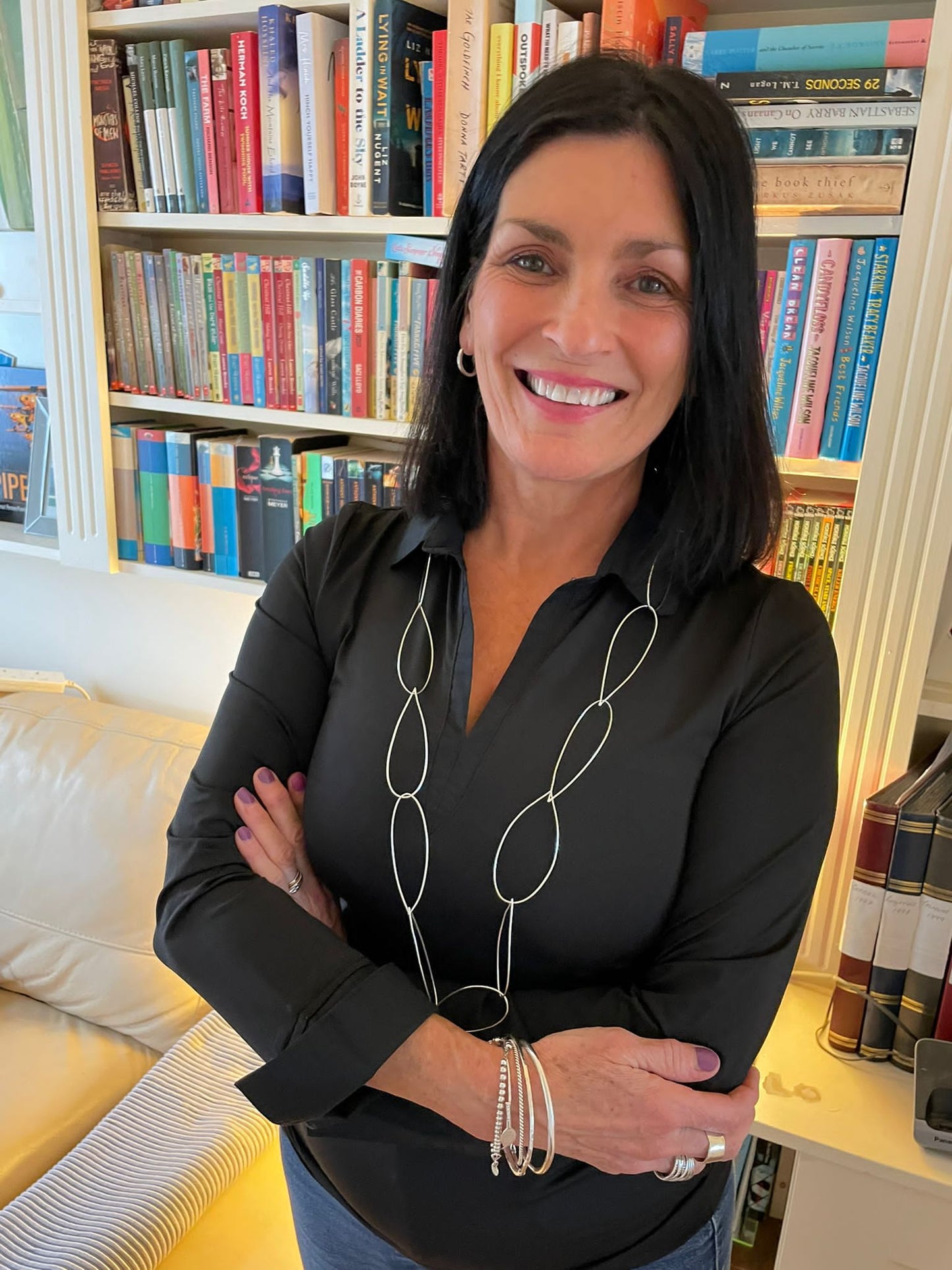 Maker Paula Fitz wearing the cascade necklace black blouse, wearing silver bangles, black hair