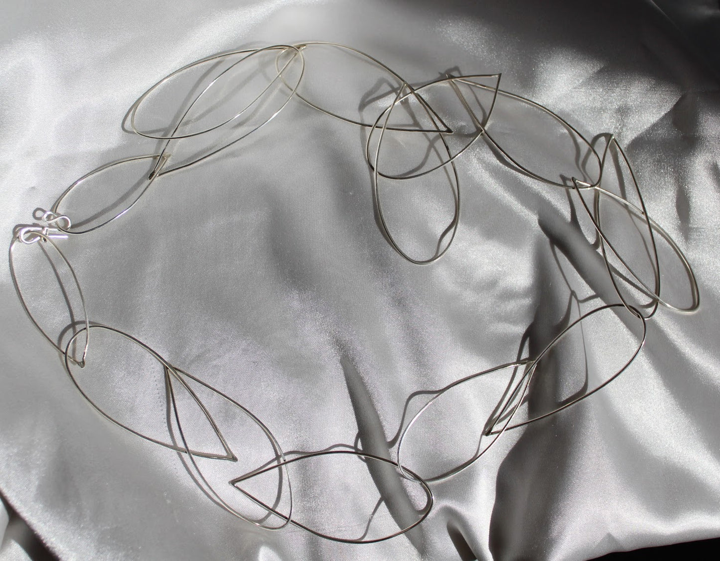 handmade sterling silver long necklace. made from silver wire in the shape of tear drop. each link is hand made and then the links are the size of the space between your thumb and pointer finger if you put your thumb on your pointer as if ti pick something up!