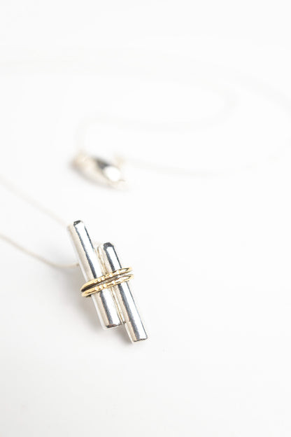 sterling silver pendant with gold embellished piece on the front shown here with a matching pendant with magnetic clasp