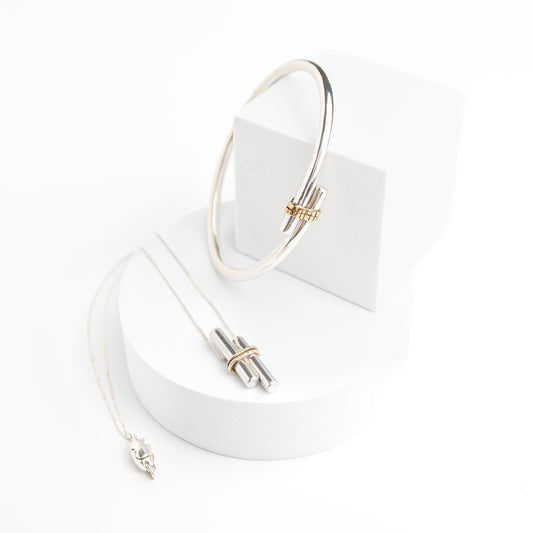 sterling silver solid bangle with gold embellished piece on the front shown here with a matching pendant with magnetic clasp