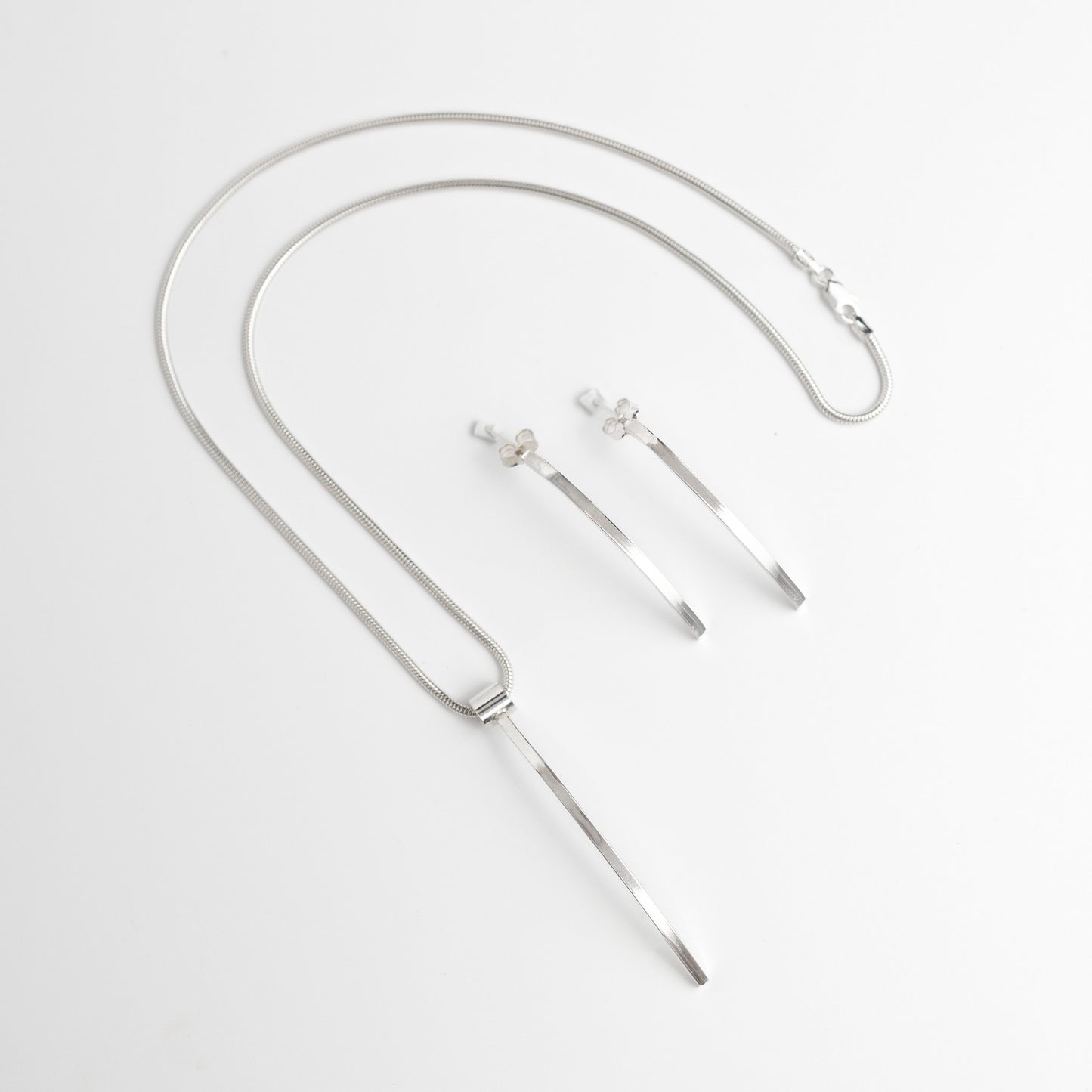 Sterling silver pendant necklace. Clean line classy pendant shaped like a narrow lond piece of 2mm square silver on a silver snake chain pictured with matching earrings 
