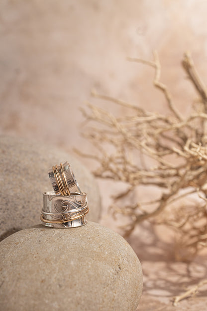 two rings stacked pictured on a brown sandstone