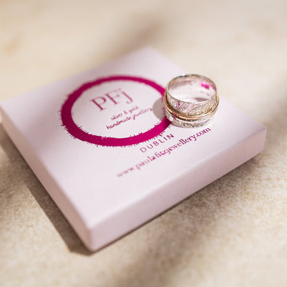 sterling silver spinner textured finished with downward bark like markings finished 3 gold filled outer rings pictured with pink gift box