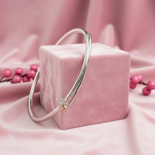 white display stand with sterling silver handmade solid silver bangle with a golf club and golf ball motif