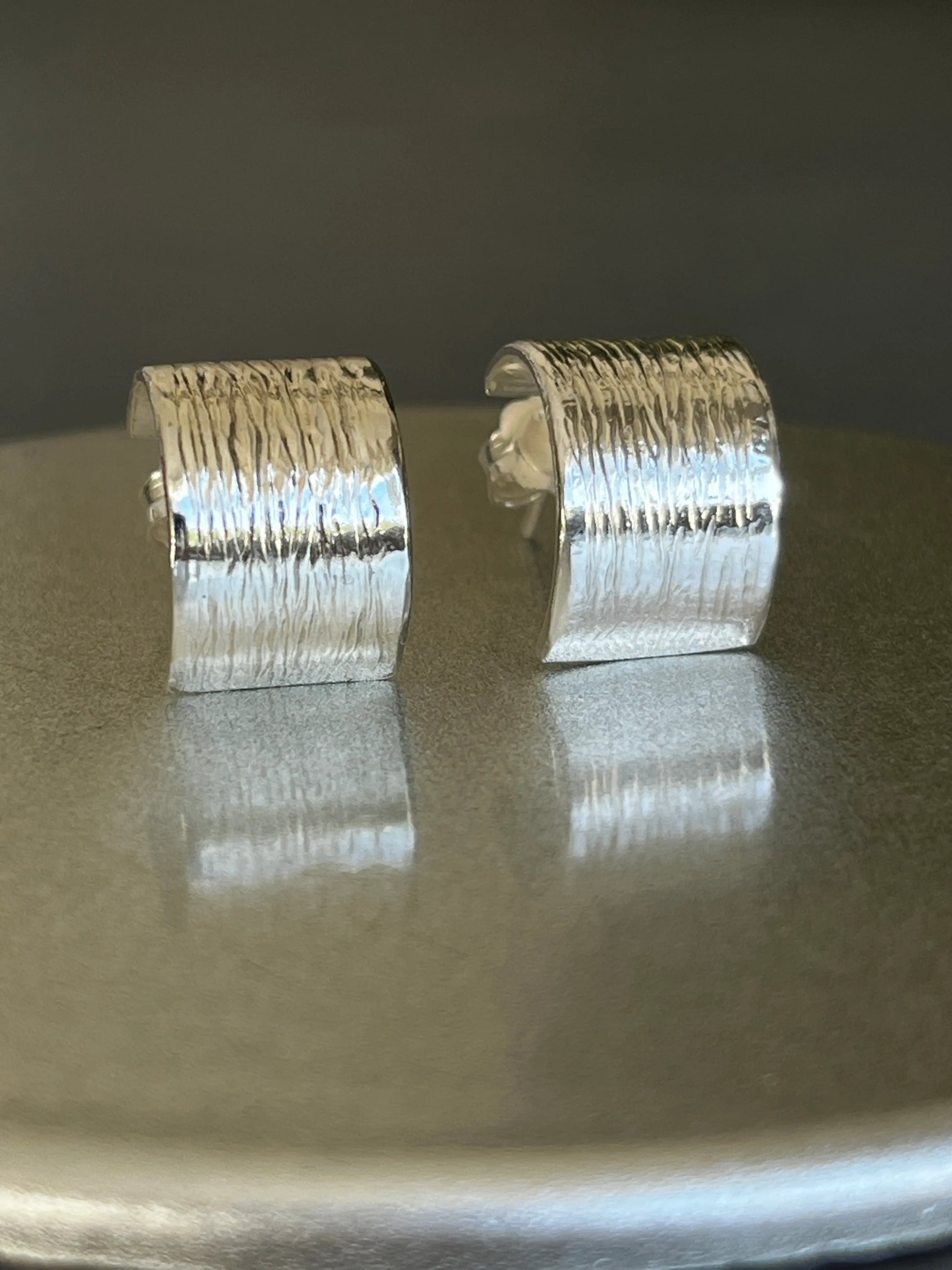 silver earrings on a shiny surface