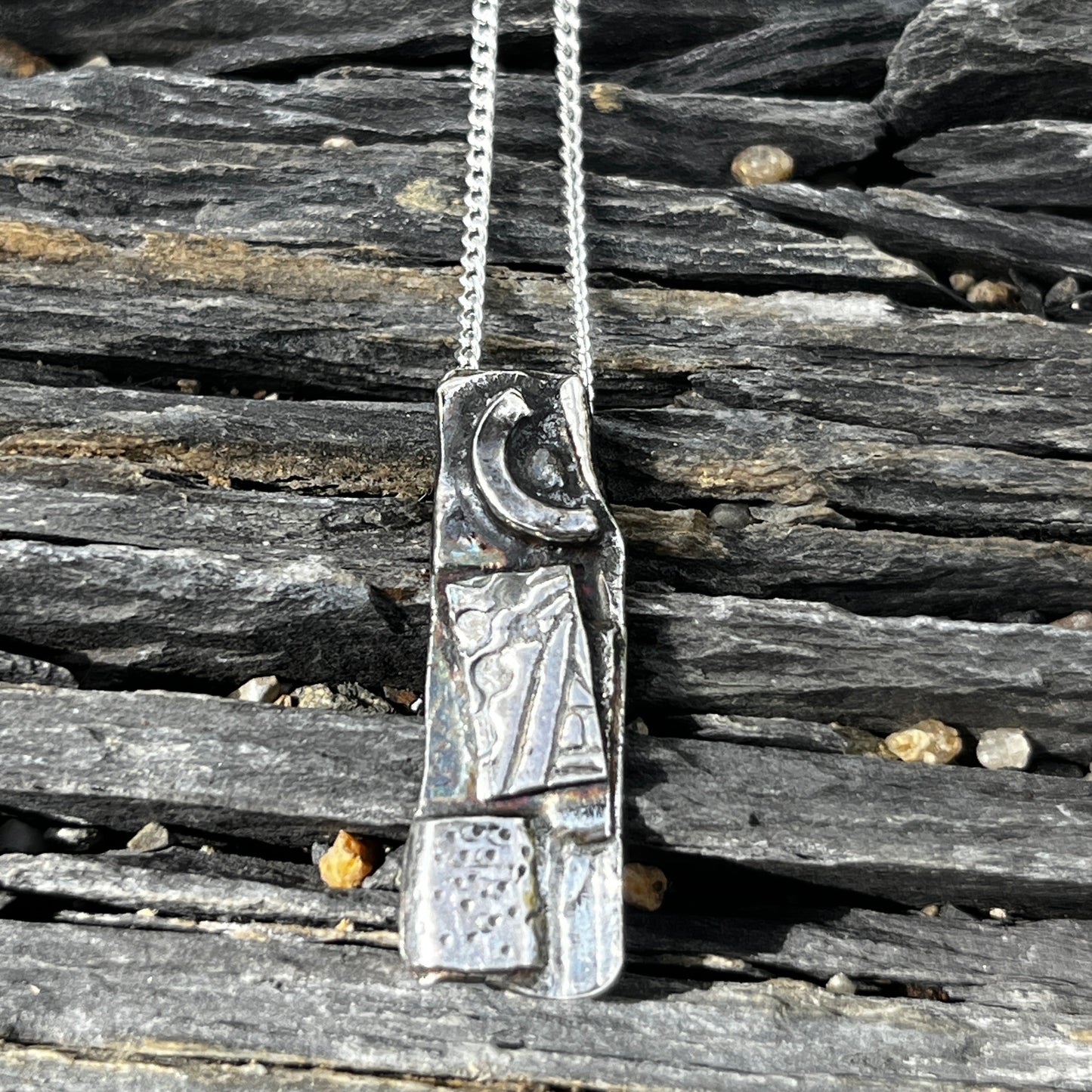 Silver necklace with a detailed clasp on a wooden surface