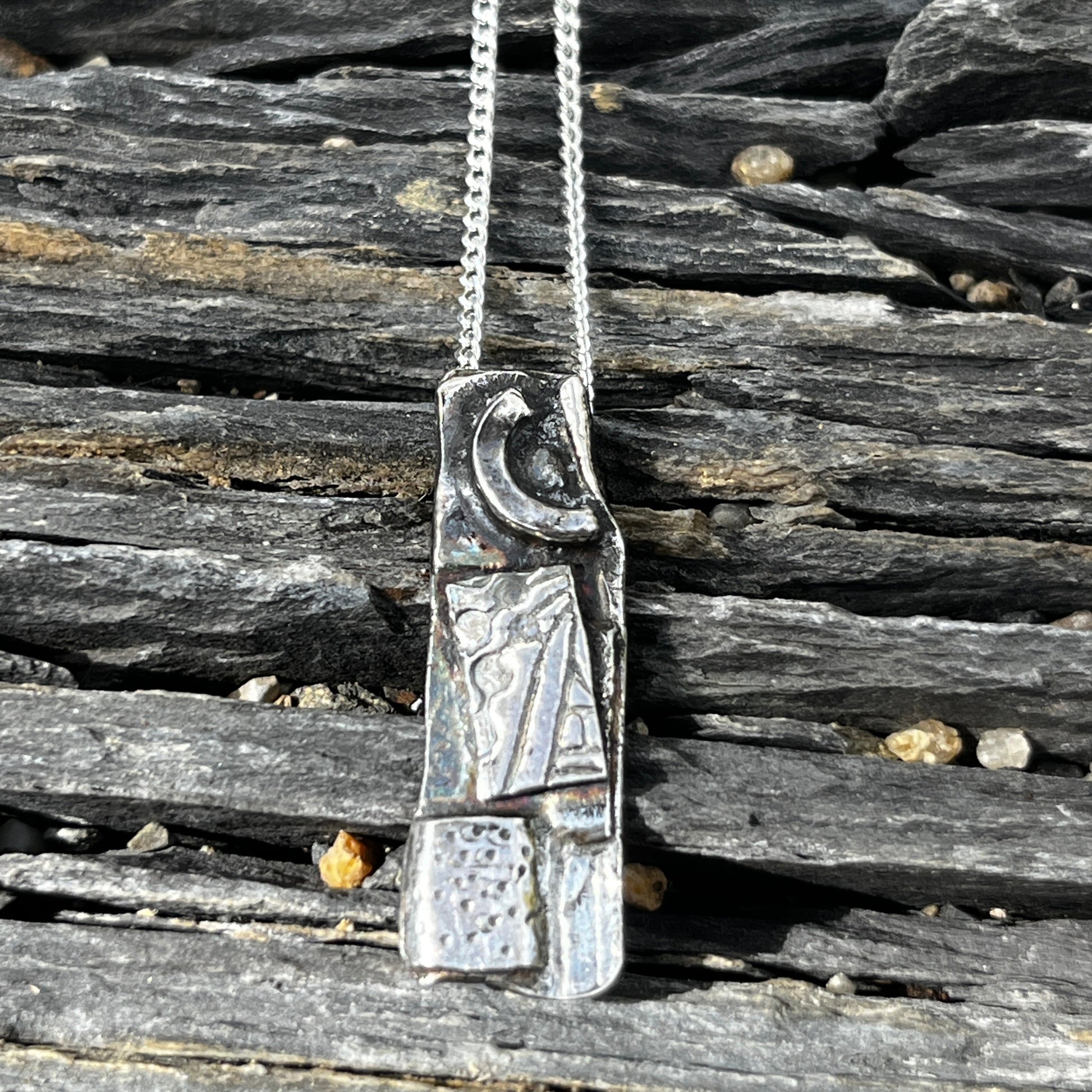 Silver necklace with a detailed clasp on a wooden surface
