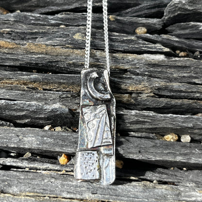 Silver necklace with a detailed clasp on a wooden surface
