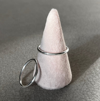 White felt cone with a silver ring on a gray surface