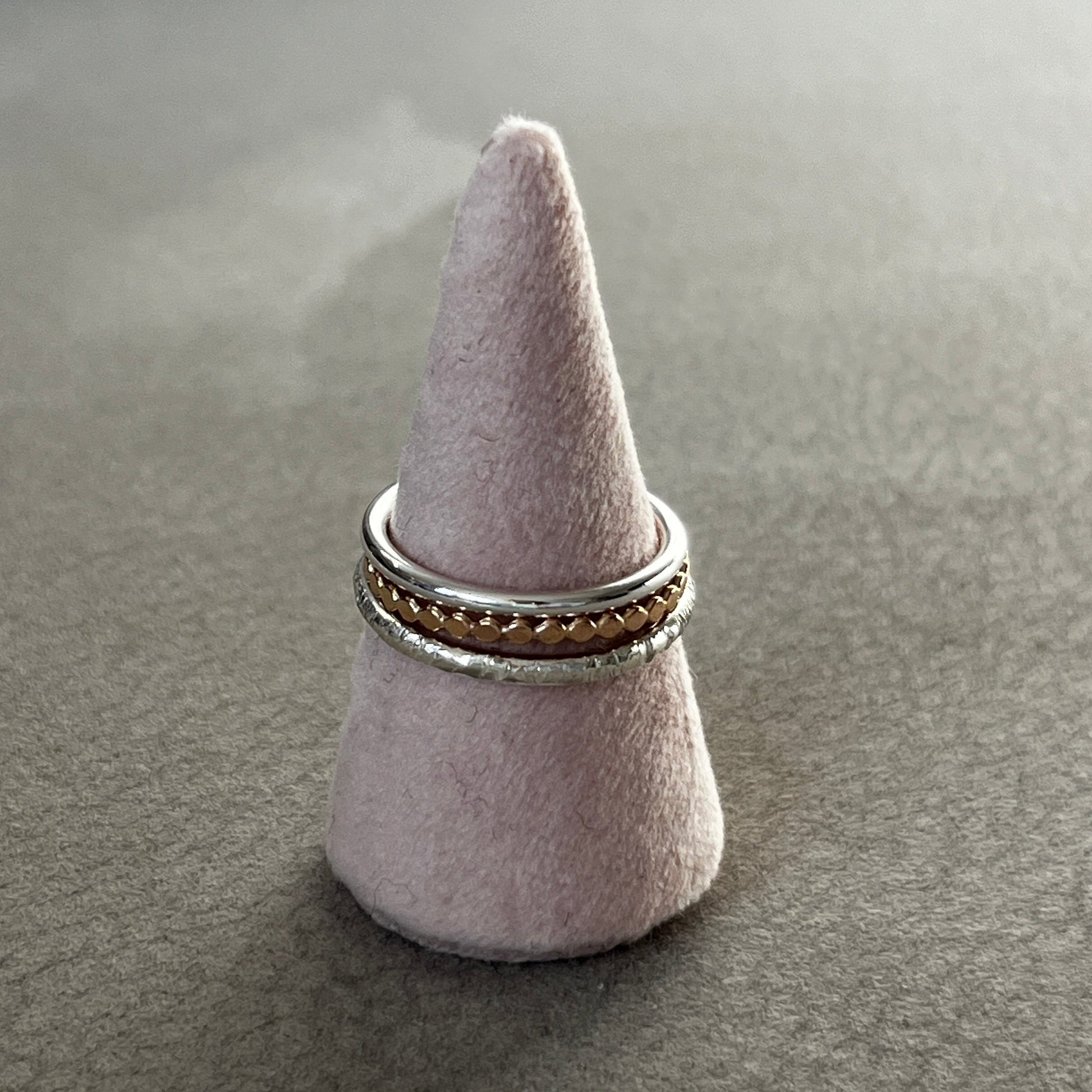 Ring on a cone-shaped gray stand against a gray background