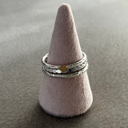 Two silver rings stacked on a cone-shaped gray stand against a gray background