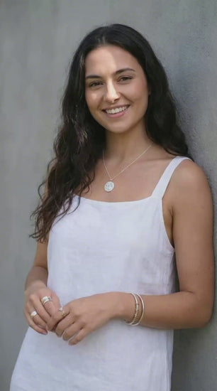 young woman in a white dress wearing silver jewellery