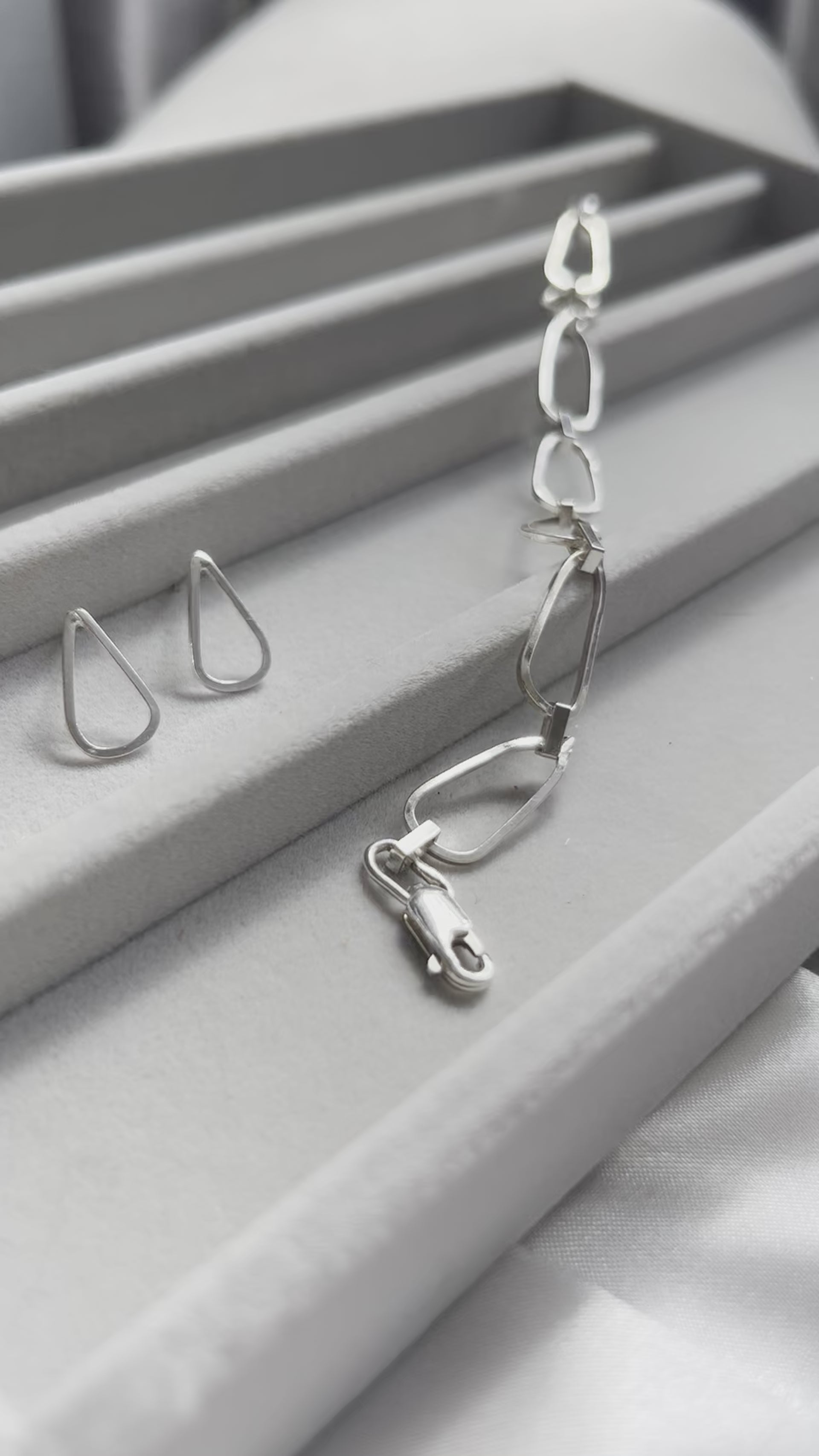 droplet shaped silver earrings with waterflow handmade silver bracelet in a jewellery box