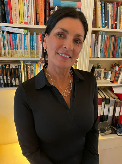 Maker Paula Fitz wearing the cascade necklace black blouse black hair library in the background