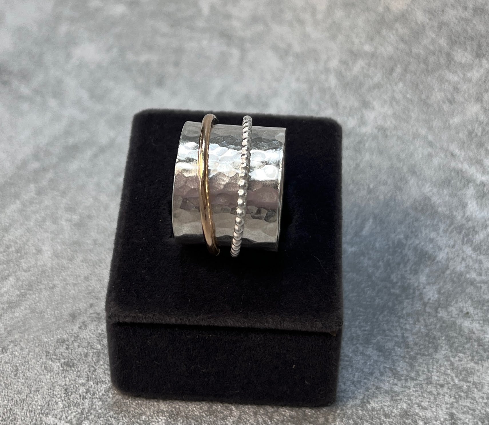 hammer finished spinner ring with a gold spinner and a silver spinner