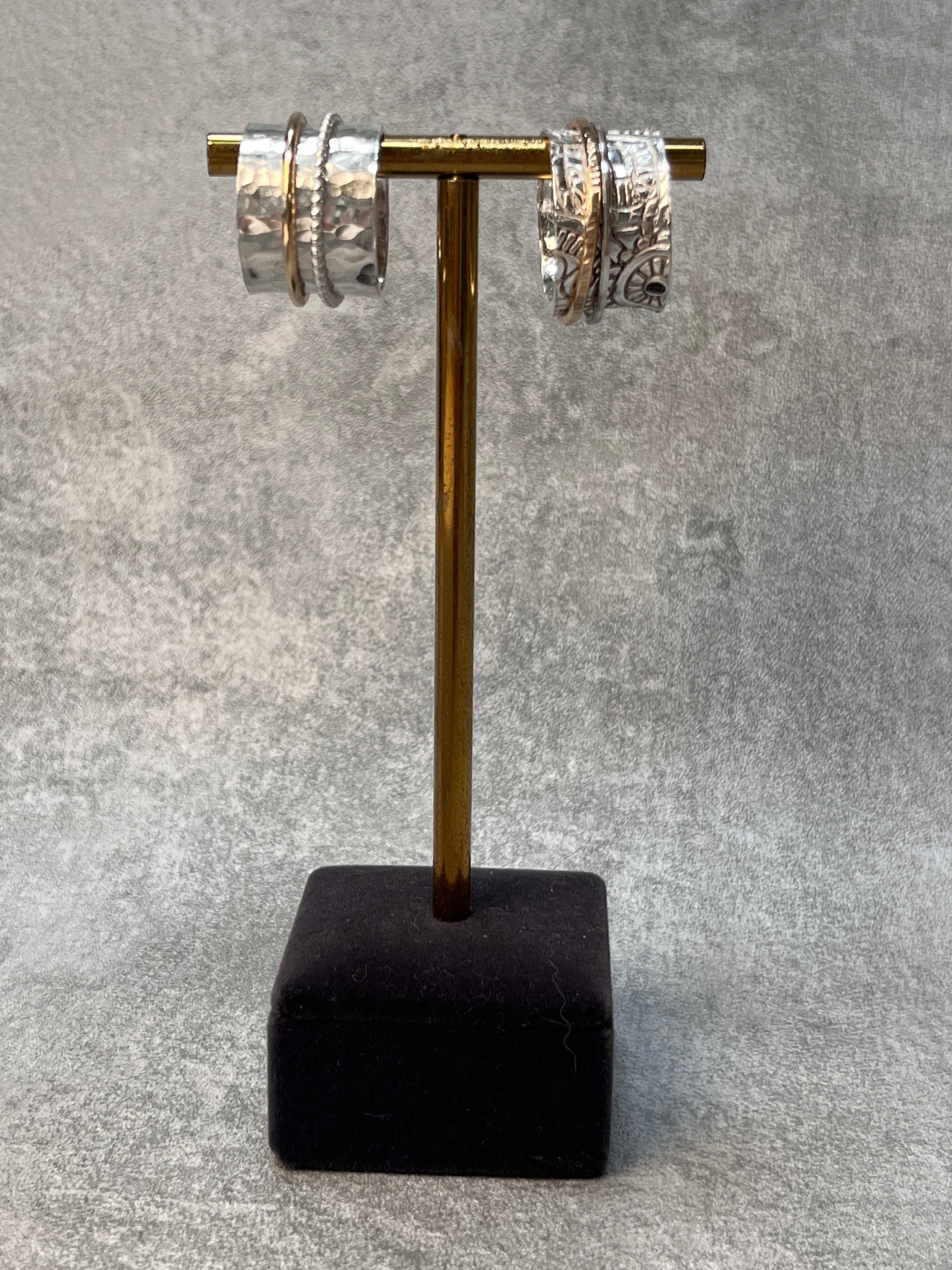 two sterling silver spinner rings on a jewellery stand
