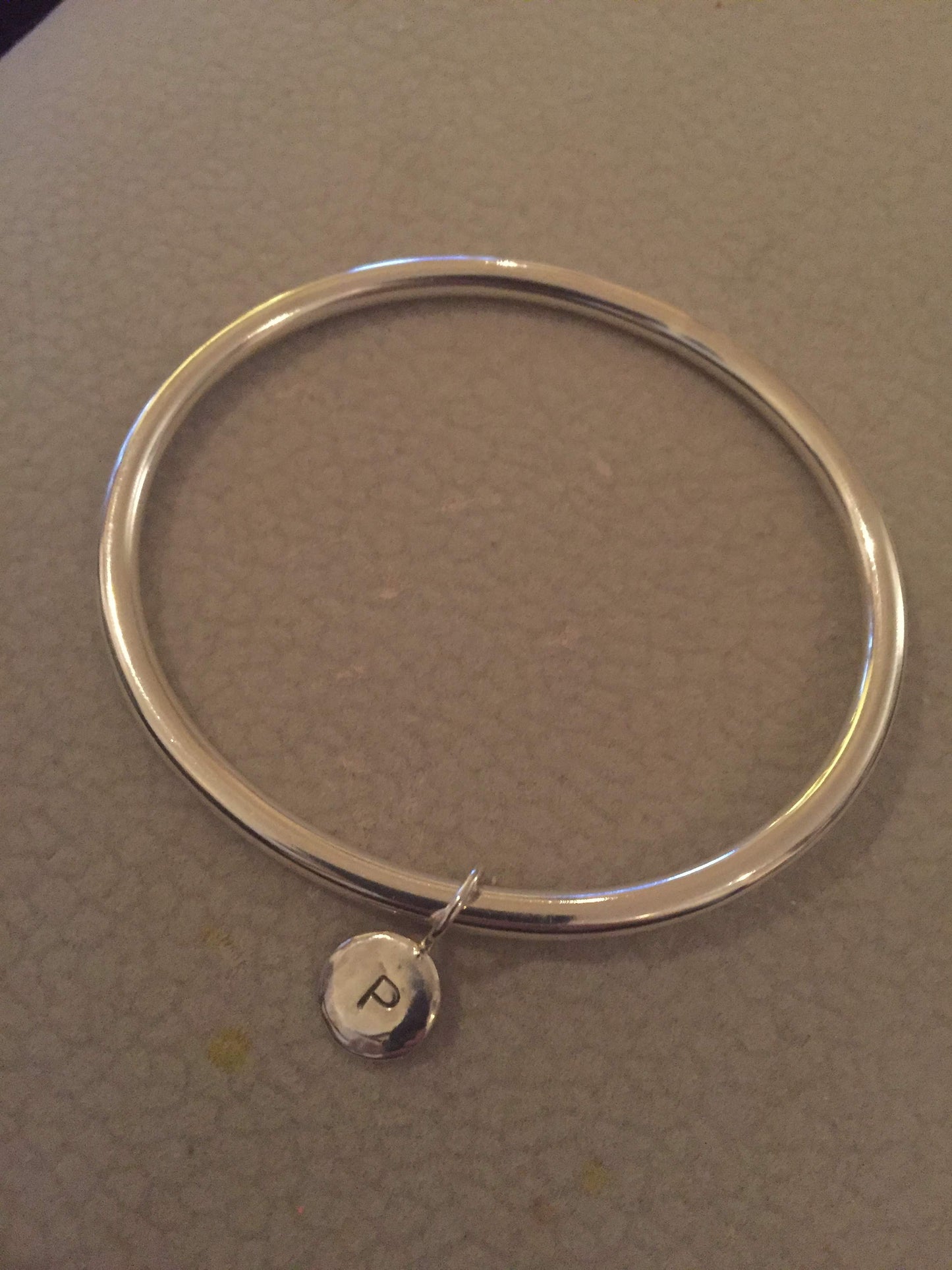 solid handmade 925 sterling silver bangle with silver disc and the initial P secured with a secure sterling silver closed jump ring