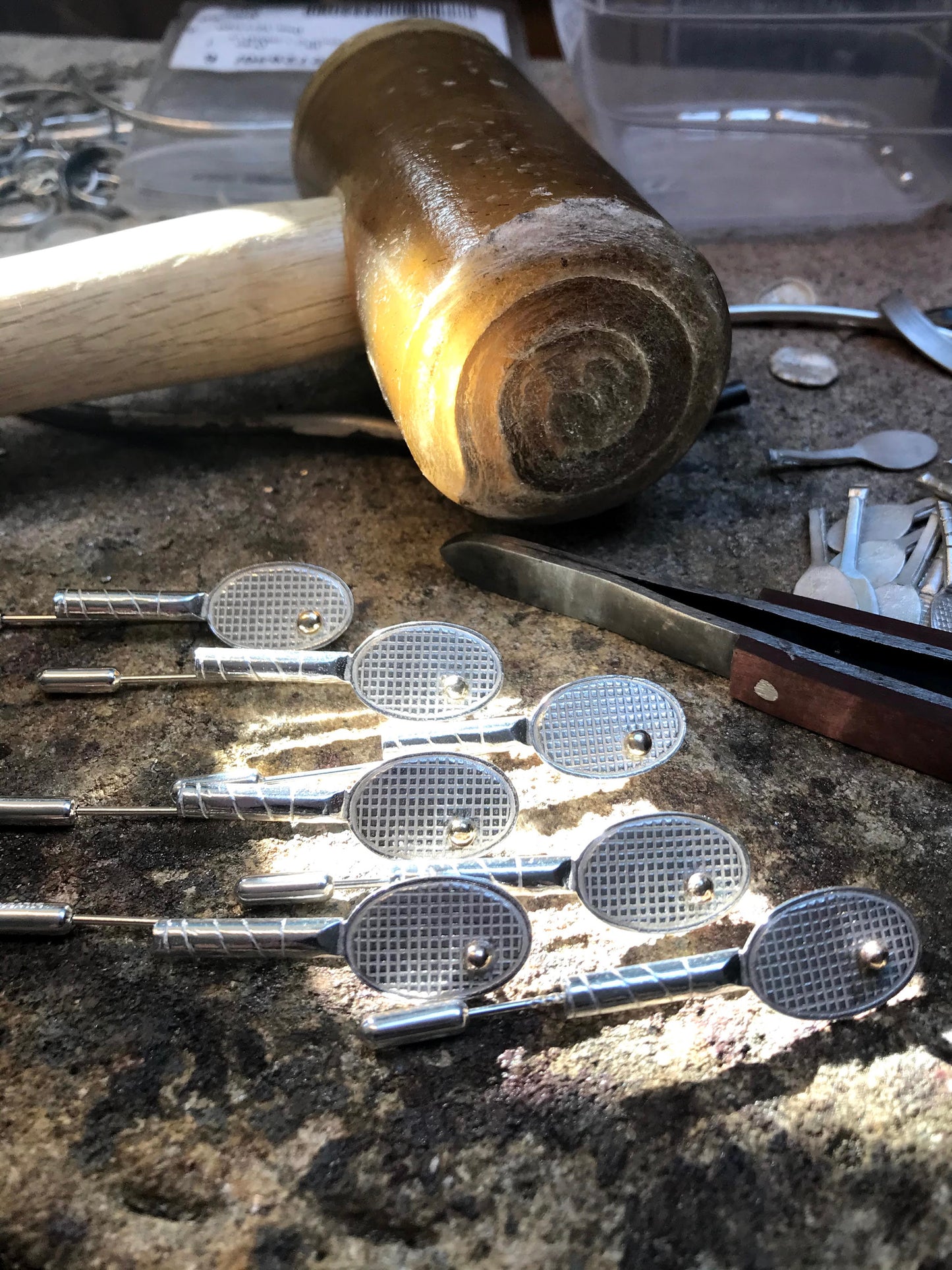 seven sterling silver tennis racket shaped broach/stick pins handmade with 9ct gold ball. Pictured with traditional rawhide mallet