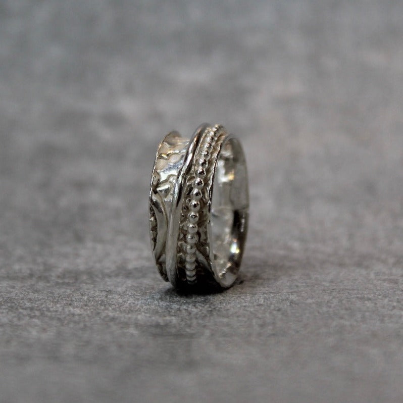 Hand embellished spinner ring sterling silver on a grey background