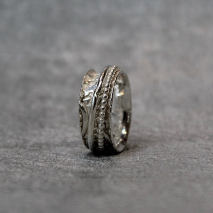 Hand embellished spinner ring sterling silver on a grey background