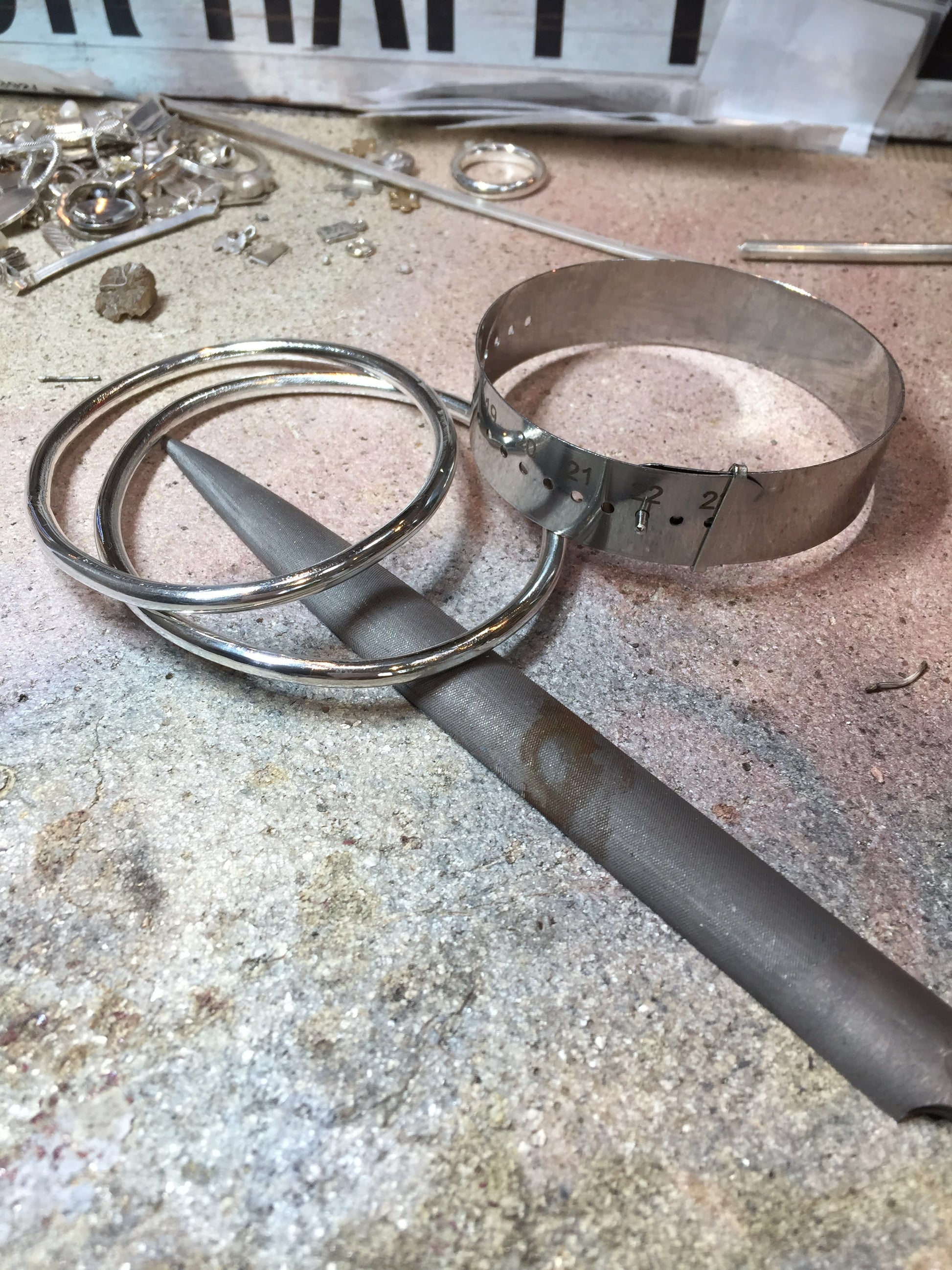 Sterling silver made in Dublin bangles on work bench with measuring device and file