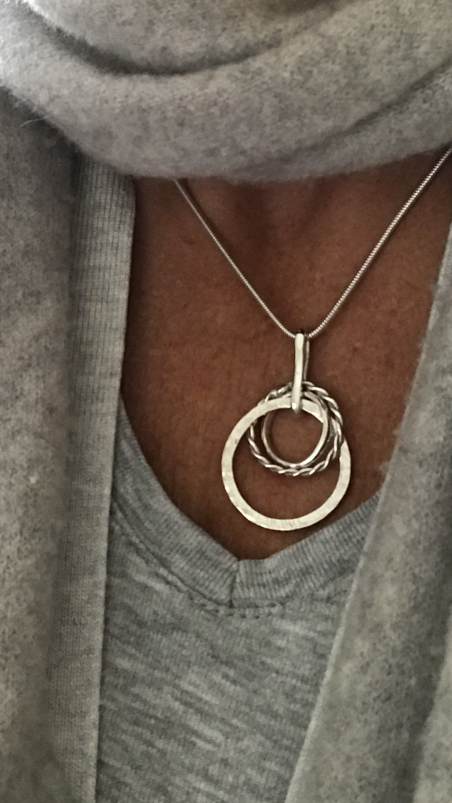 three circles intertwined twisted hammered and mirror 40cm snake chain sterling silverSterling silver mixed loop necklace. Three circles of silver. One hammered, one twisted and one polished. Hangs on a sterling silver snake chain with a secure 'lobster claw' closing clasp.pictured here on a model wearing a grey cashmere scarf