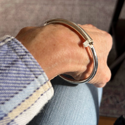 model is wearing sterling silver handmade solid silver bangle with a golf club and golf ball motif