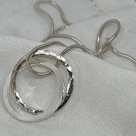 two sterling silver circles intertwined on a sterling silver snake necklace
