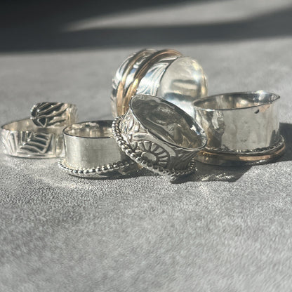 a collection of five various spinner rings some with gold filled outer rings some with silver outer spinner rings all patterned