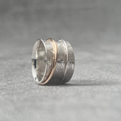 stg silver spinner ring one thick band 11mm wide with . Over it spins a silver beaded thin ring 1.5mm wide. Leafy imprinted pattern hand embellished surface on main ring, two spinner rings on the outer surface one silver one gold filledThe outer ring spins with your touch