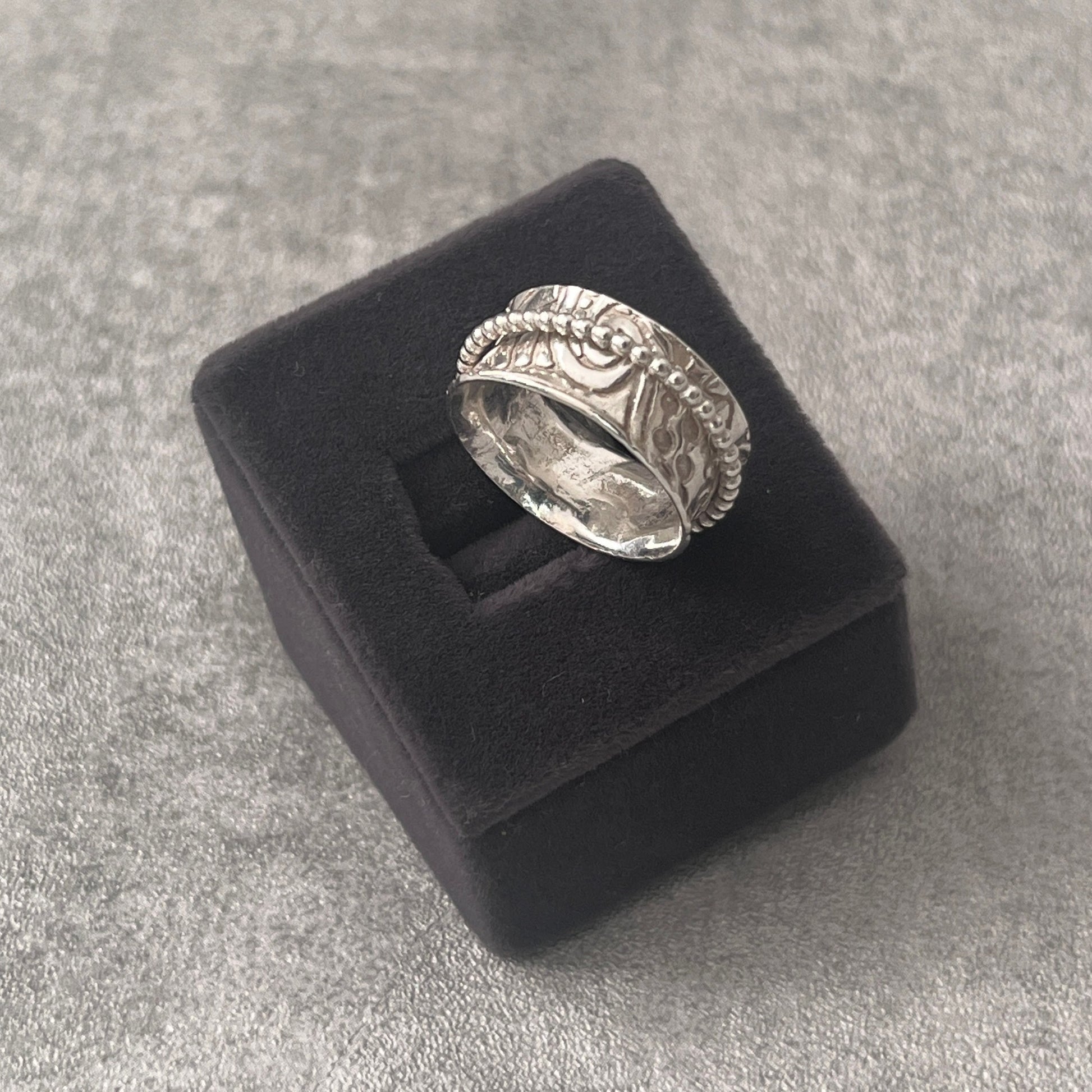 Spinner ring in a grey velvet box
