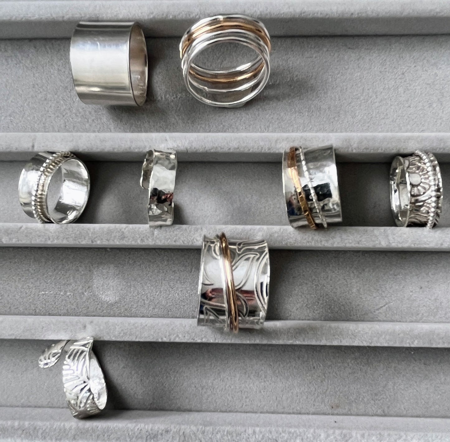 several sterling silver spinner rings in a jewellery box