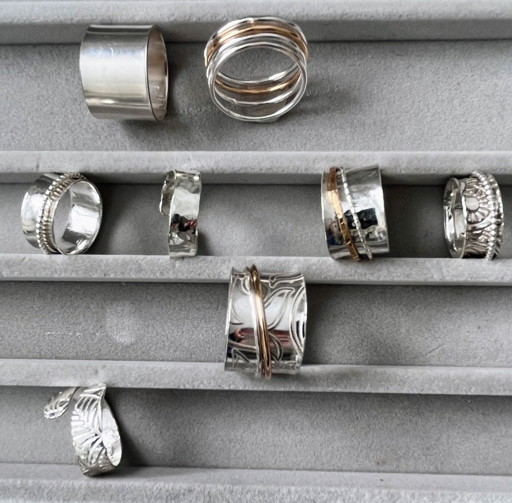 several sterling silver spinner rings in a jewellery box