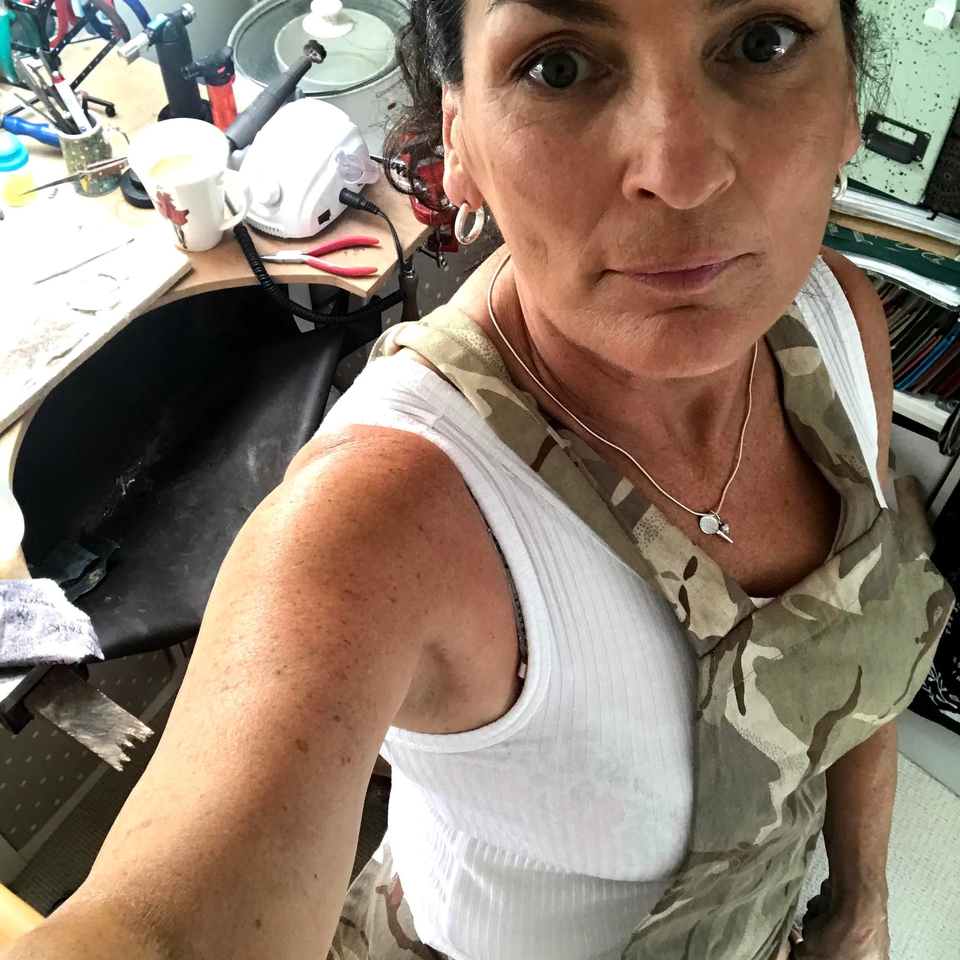 Paula Fitzgibbon silversmith with work apron in studio work bench hammer rawhide mallet 