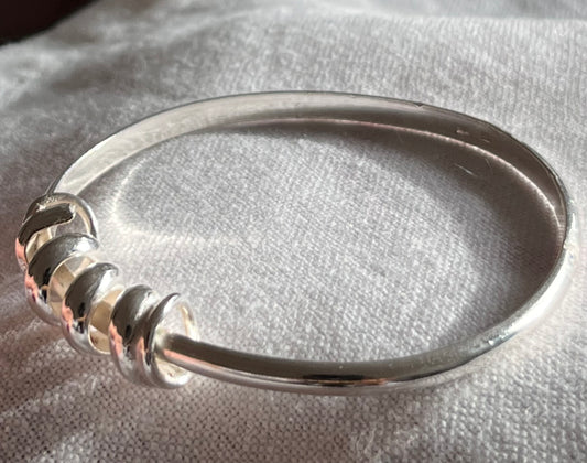 handmade sterling silver bangle. The profile of the silver band is D shaped.  with a twisted rolled strip of sterling silver to represent a wave perfect for the swimmer in you life